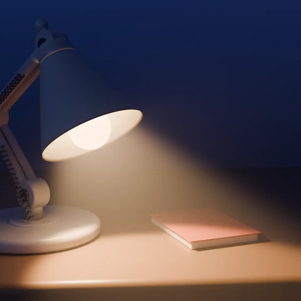 A white desk lamp lighting a notebook on a desk at night